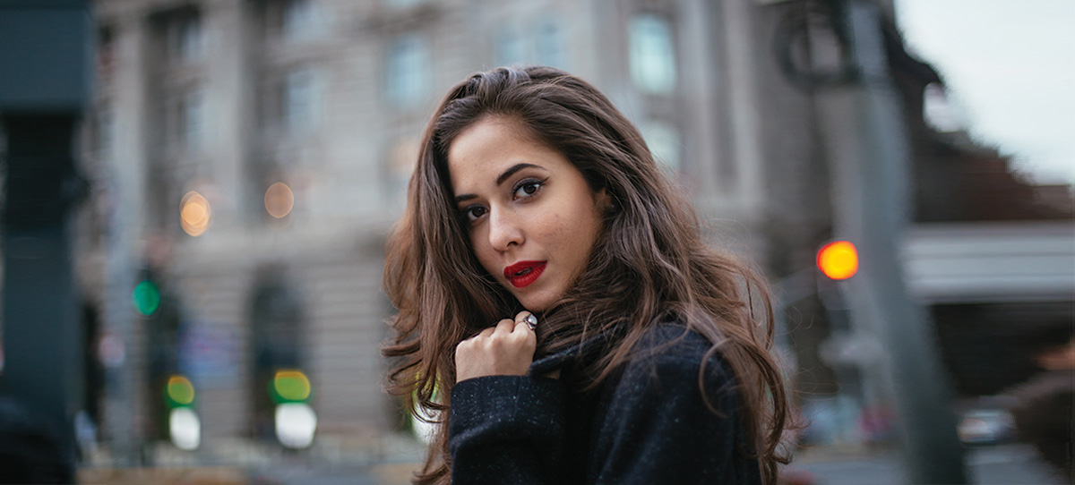 Brunette girl with red lipstick in the city