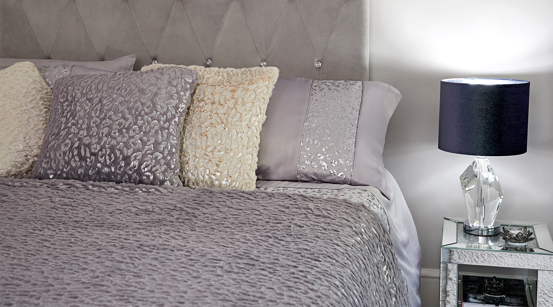 Sequin patterned bedding and a bedside lamp